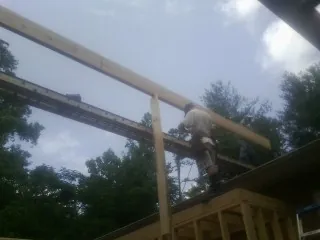 Carpenter setting a ridge beam over a new addition frame — Ice Dam Removal by Roofing Brothers in Huntington Station
