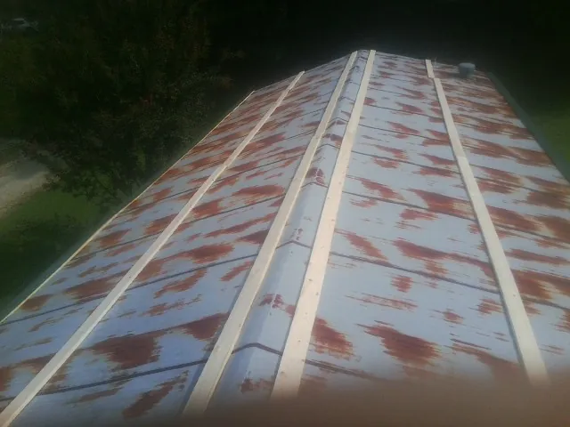 Rusted metal roof panels with new wood purlins before replacement — Storm Damage Roof Repair in Huntington Station by Roofing Brothers