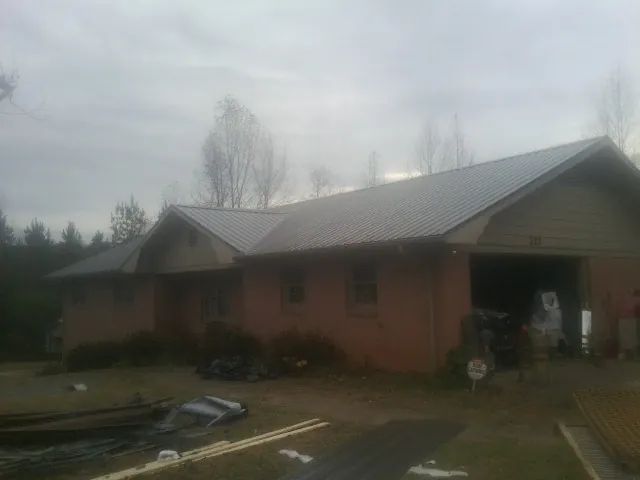 Gray metal roof on a stucco house with an attached garage in Huntington Station